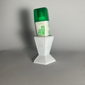 Peut inclure: Un support en céramique blanc avec un flacon de colle liquide MONO MULTI vert et blanc à pointe large.
