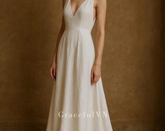 May include: A white, sleeveless V-neck dress with a flowing skirt. The dress has a fitted bodice and a simple, elegant design. The text "GracefulVN" is visible on the lower part of the dress.