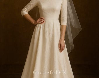 Könnte beinhalten: Cremefarbenes Hochzeitskleid mit Rundhalsausschnitt und Dreiviertelärmeln. Das Kleid hat einen weiten Rock und wird mit einem transparenten Schleier kombiniert. Der Text "Graceful VN" ist auf dem Kleid zu sehen.