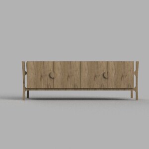 Op de afbeelding: Een houten kast met twee deuren en unieke gebogen poten. De kast heeft een lichtbruine houtkleur.