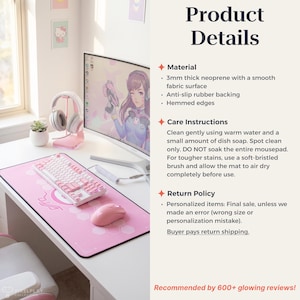 May include: A pink gaming mousepad with a white border, a white keyboard, and a pink mouse sit on a white desk. The mousepad has a hexagonal pattern and a logo. A computer monitor, headphones, and a small plant are also visible.