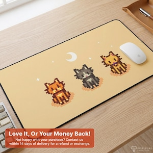 May include: A rectangular mousepad with a light tan background featuring three pixelated cats in orange, gray, and yellow. A white crescent moon and stars are also on the mousepad. A white mouse is on the right side of the mousepad.