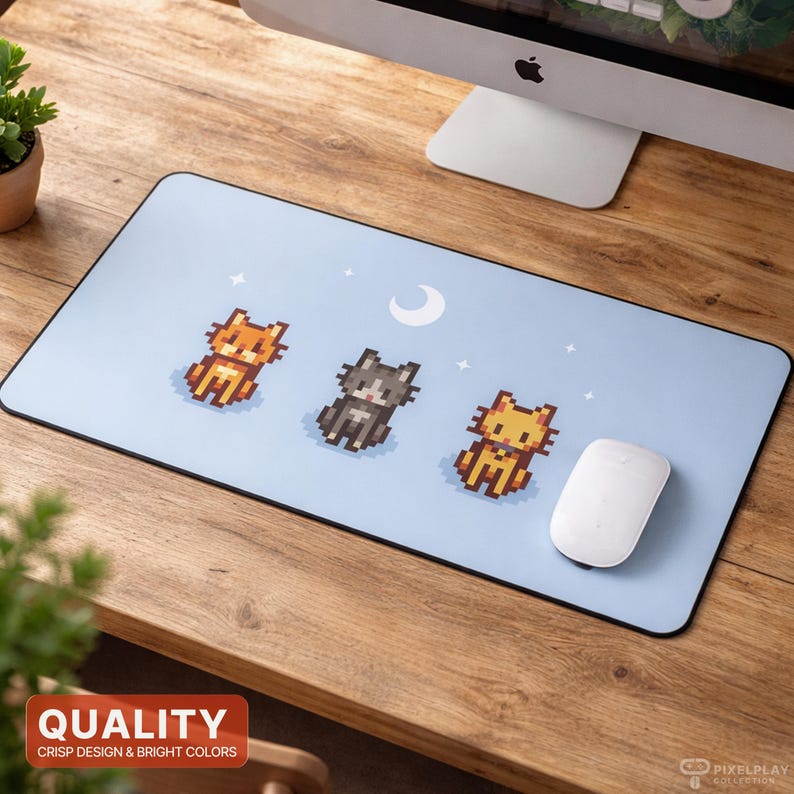 May include: A light blue rectangular mousepad featuring three pixelated cat illustrations in orange, gray, and yellow. The design includes a crescent moon and stars. A white mouse rests on the pad.