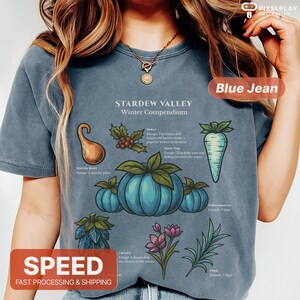 May include: Blue jean colored t-shirt featuring a graphic of the "Stardew Valley Winter Compendium." The design includes illustrations of various winter crops and the text "SPEED FAST PROCESSING & SHIPPING."