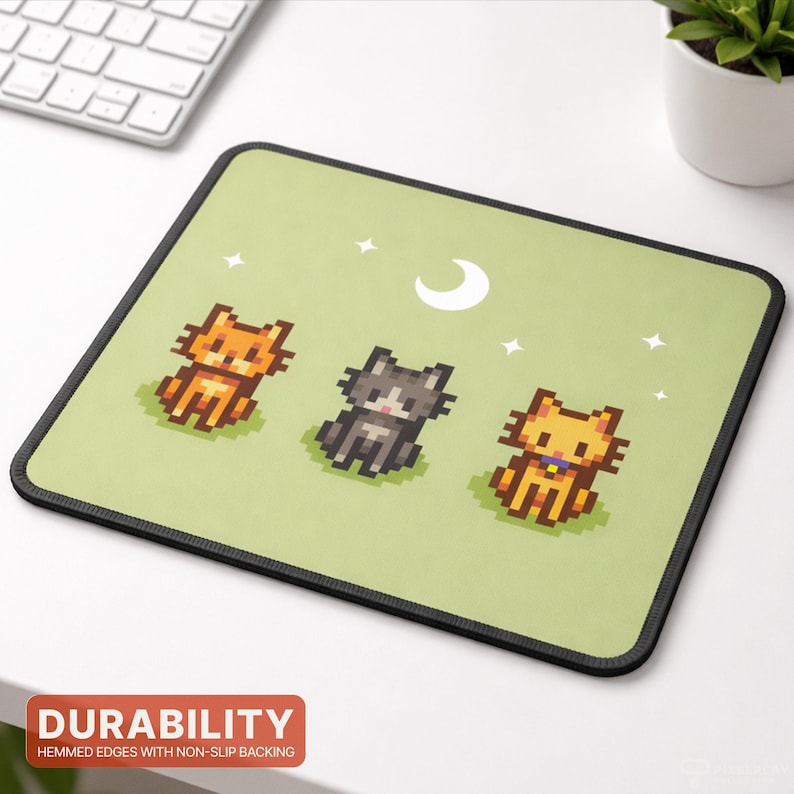 May include: Square mousepad with a light green background featuring three pixelated cats in orange, gray, and yellow. A white crescent moon and stars are above the cats. The mousepad has a black border and the word "DURABILITY" is printed on the bottom.