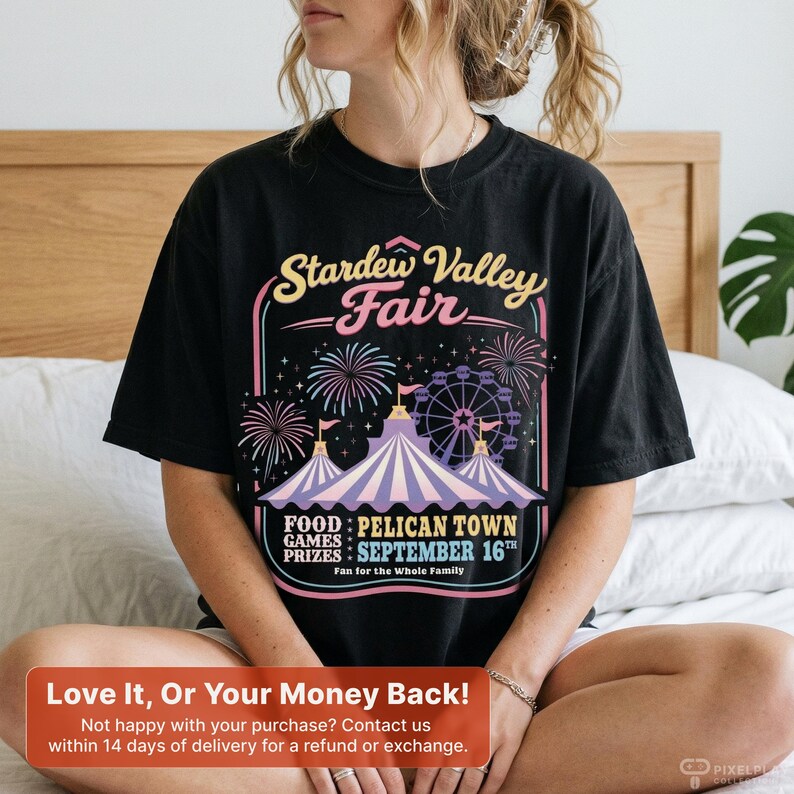 Może przedstawiać: Czarny t-shirt z kolorową grafiką Stardew Valley Fair. Projekt zawiera fajerwerki, diabelski młyn i tekst "FOOD: PELICAN TOWN GAMES PRIZES: SEPTEMBER 16TH." Codzienny element garderoby dla fan&oacute;w.