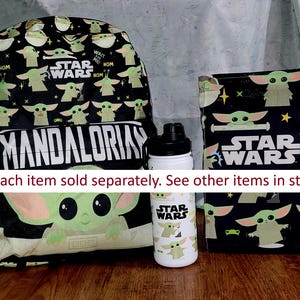 Pu&ograve; includere: Uno zaino, una borsa per il pranzo e una borraccia neri a tema Star Wars. Lo zaino e la borsa per il pranzo presentano un motivo ripetuto di Grogu, con le parole "Mandalorian" e "Star Wars". La borraccia &egrave; bianca con un design Grogu.