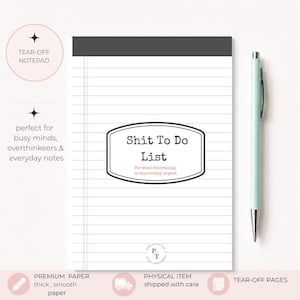 May include: A white tear-off notepad with horizontal lines and a dark gray top header. The center features a black-bordered label with the text "Shit To Do List" and "for when everything is apparently urgent" in pink. A light green pen sits to the right.
