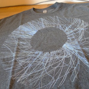 Angled close-up of the upper portion of the blue radial circle print showing the fine generative lines against the dark fabric