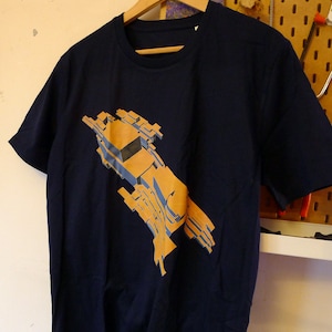 Może przedstawiać: Koszulka w kolorze granatowym z nadrukiem abstrakcyjnego wzoru w kolorze żółtym i niebieskim.