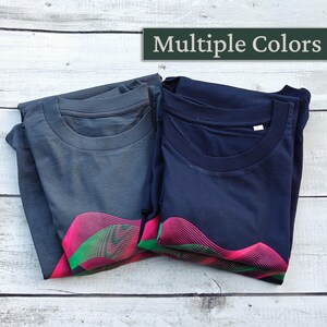 Two folded t-shirts in india ink grey and navy showing the pink and green wave print, multiple colours label