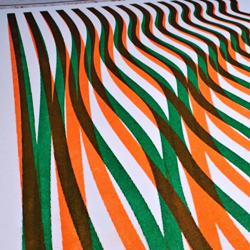 Macro detail of the abstract riso print with intersecting green, orange and brown wavy lines printed on white paper