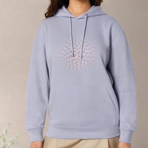 May include: A light purple hoodie featuring a large, colourful, geometric design on the front. The design is a circle with a pattern of pink, blue and white dots.
