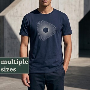 Op de afbeelding: Marineblauw t-shirt met een wit geometrisch ontwerp. Het ontwerp heeft een centrale cirkel met uitstralende lijnen, waardoor een zonnestraaleffect ontstaat. Het shirt heeft korte mouwen en een ronde hals.
