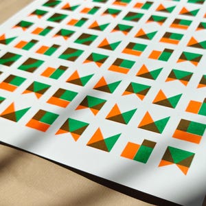 Angled close-up of the geometric tile riso print revealing the grainy ink texture of the green and orange shapes