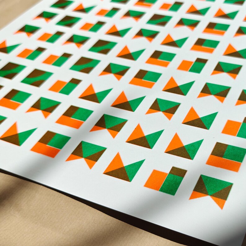 Angled close-up of the geometric tile riso print revealing the grainy ink texture of the green and orange shapes