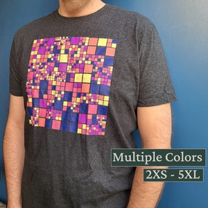 以下が含まれることがあります： カラフルな幾何学模様がプリントされたダークグレーのTシャツ。模様はピンク、イエロー、パープル、ブルーの正方形で構成されています。Tシャツには「Multiple Colors」と「2XS - 5XL」の文字がプリントされています。