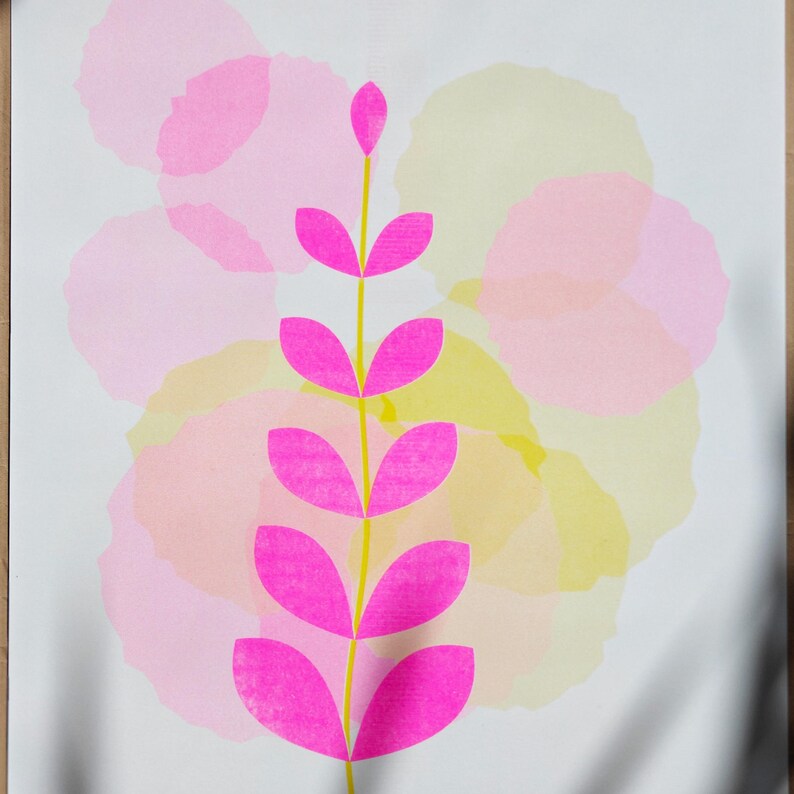 The full A3 botanical riso print — a fluorescent pink leaf sprig over soft pink and yellow watercolour-like circles on white paper