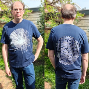 Front and back of the navy 2-sided t-shirt worn outdoors — particle burst on the front, handwritten source code on the back