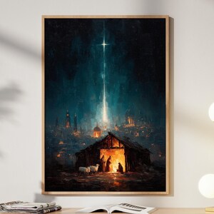May include: A framed art print depicting a nighttime scene with a bright star shining over a barn. The artwork features a warm color palette with a focus on the barn and figures inside. The print is displayed on a light wood cabinet.