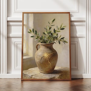 May include: A framed art print showing a still life. It features a tan vase with a golden crack, holding green olive branches. The vase is on a stone surface, set against a soft, neutral background. The frame is wooden.