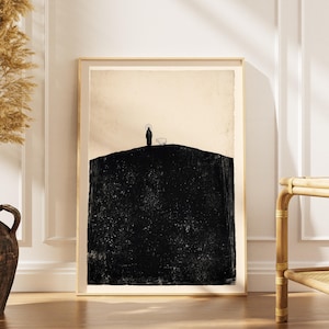 Könnte beinhalten: Gerahmter Kunstdruck mit minimalistischer Landschaftsdarstellung. Das Kunstwerk zeigt einen schwarzen Hügel mit einer Figur und einem Schaf vor cremefarbenem Himmel. Der Rahmen ist helles Holz, für eine schlichte und ruhige Ästhetik.