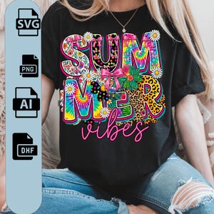 Puede incluir: Camiseta negra con un gráfico colorido de "SUMMER vibes". El texto presenta patrones florales, tie-dye y leopardo, con lazos rosas y acentos de margaritas. La camiseta la lleva una persona con vaqueros.