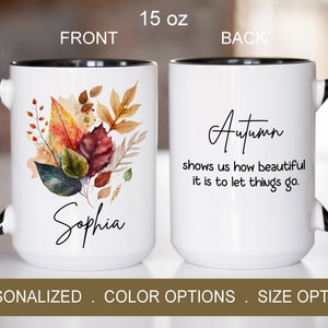 May include: White ceramic mug with a black rim and handle. The front features a watercolor illustration of autumn leaves and the name "Sophia". The back features the text "Autumn shows us how beautiful it is to let things go."