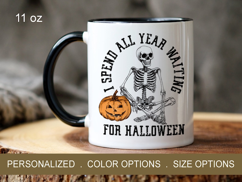 May include: White ceramic mug with a black handle. The mug has a skeleton sitting on a pumpkin with the text "I spend all year waiting for Halloween".