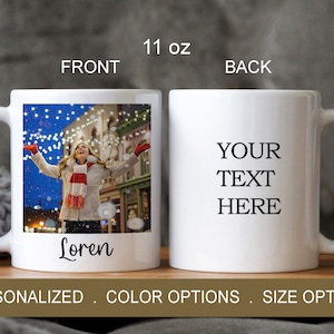 Puede incluir: Taza de cer&aacute;mica blanca con una foto de una persona en una escena de invierno con luces y nieve. La taza tiene el texto "Loren" en la parte delantera y "YOUR TEXT HERE" en la parte posterior. La taza es de 11 onzas.