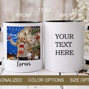 Puede incluir: Taza de cer&aacute;mica blanca con borde y asa negros. La parte delantera de la taza tiene una foto de una persona con los brazos en alto frente a una calle de la ciudad por la noche. El texto "Loren" est&aacute; impreso debajo de la foto. La parte posterior de la taza tiene el texto "YOUR TEXT HERE".