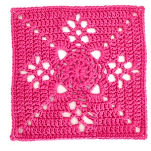 May include: A square, handmade crochet piece in a vibrant fuchsia color. The design features an openwork pattern with a central floral motif and radiating star-like elements. The edges are neatly finished, showcasing the detailed craftsmanship.