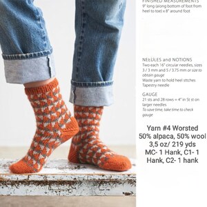 Puede incluir: Calcetines de punto con un patr&oacute;n geom&eacute;trico naranja y blanco, usados con vaqueros azules. Los calcetines miden 22,86 cm de largo y 20,32 cm alrededor del pie. El hilo es 50% alpaca y 50% lana. La imagen muestra las medidas.