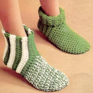 May include: A pair of green and white crocheted slippers. One slipper has a striped pattern, while the other is solid green.