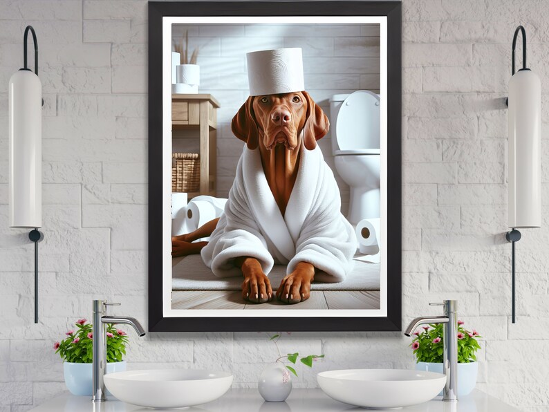 May include: A brown and white dog wearing a white bathrobe and a toilet paper roll on its head. The dog is sitting in a bathroom with a toilet and other toilet paper rolls in the background.