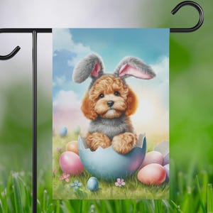 May include: A brown and white dog wearing bunny ears sits inside a blue and white cracked Easter egg. The dog is surrounded by colorful Easter eggs.