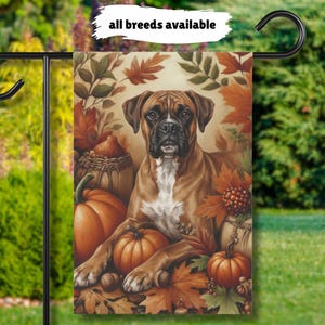 May include: A rectangular garden flag featuring a brown Boxer dog with a white chest, surrounded by orange pumpkins, acorns, and autumn leaves in shades of red, yellow, and brown. The text "all breeds available" is printed at the top of the flag.