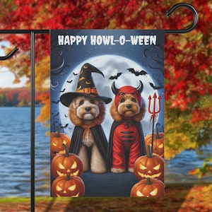 May include: A Halloween-themed garden flag with two dogs dressed up in costumes. One dog is wearing a witch's hat and the other is wearing a devil costume. The flag says "Happy Howl-O-Ween" and has a full moon and bats in the background.