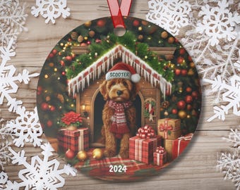 May include: A Christmas ornament featuring a brown dog with a red and white scarf sitting in a wooden doghouse decorated with lights and ornaments. The dog is wearing a Santa hat with the name "Scooter" on it. The ornament also includes the year "2024".