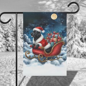 May include: A black Labrador Retriever dressed as Santa Claus pulls a red sleigh full of presents through a snowy night sky. A full moon shines brightly in the background.