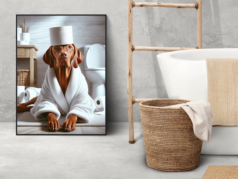 May include: A brown and white dog wearing a white bathrobe and a toilet paper roll hat is sitting on a bathroom floor. The dog is looking at the camera. There is a toilet in the background.