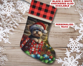 May include: Personalized Christmas stocking featuring a Yorkshire Terrier puppy wearing a Santa hat and sitting in a box of presents. The stocking is red and white checkered with a tan cuff and the name "Millie" is embroidered on the hat.