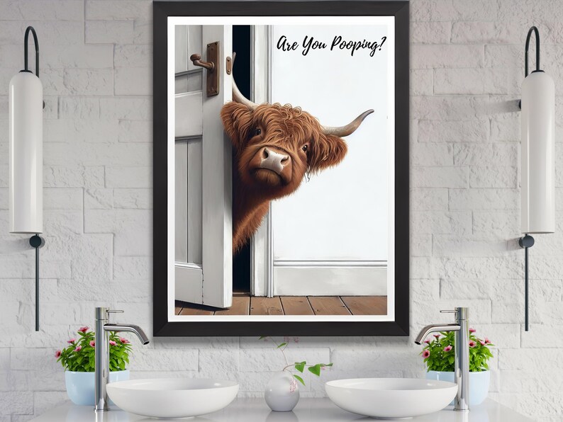 May include: A framed print of a brown and white Highland cow peeking around a white door with the text "Are You Pooping?" printed above the cow.