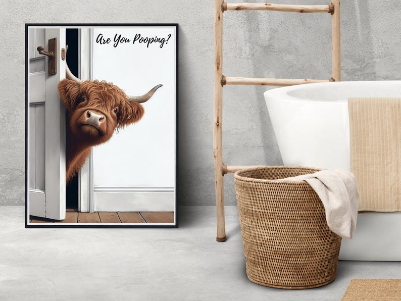 May include: A black framed print with a brown and white Highland cow peeking around a white door. The print has the text "Are You Pooping?" on it.