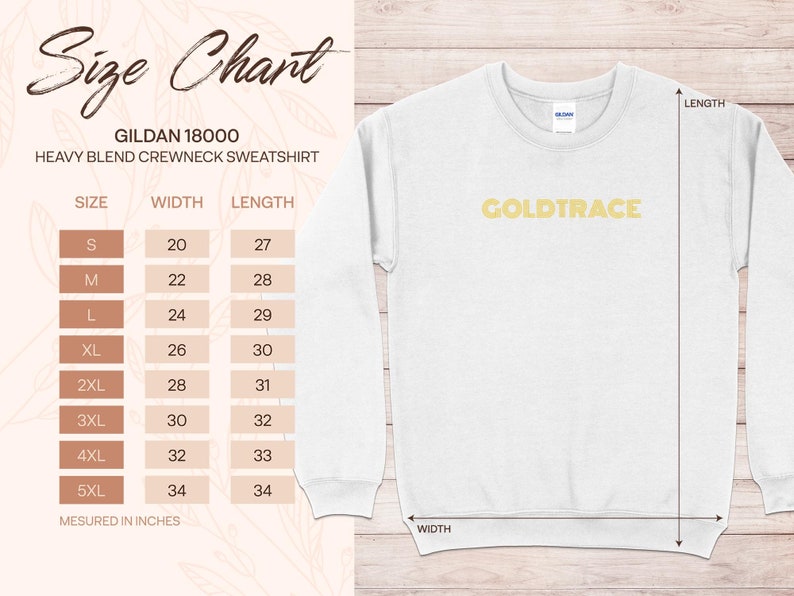 Op de afbeelding: Maattabel voor een Gildan 18000 heavy blend crewneck sweatshirt. De tabel toont de breedte en lengte in inches voor maten S tot en met 5XL. De tekst "GOLDTRACE" is in goud gedrukt op een wit sweatshirt.