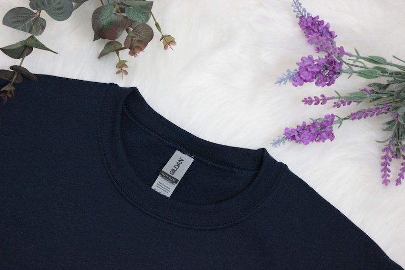 Op de afbeelding: Een donkerblauw sweatshirt met een Gildan-merketiket bevestigd aan de hals.