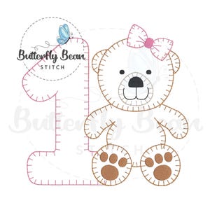 May include: Embroidered design of a brown teddy bear with a pink bow, holding a pink number one. The design includes a blue butterfly and the text "Butterfly Bean Stitch".