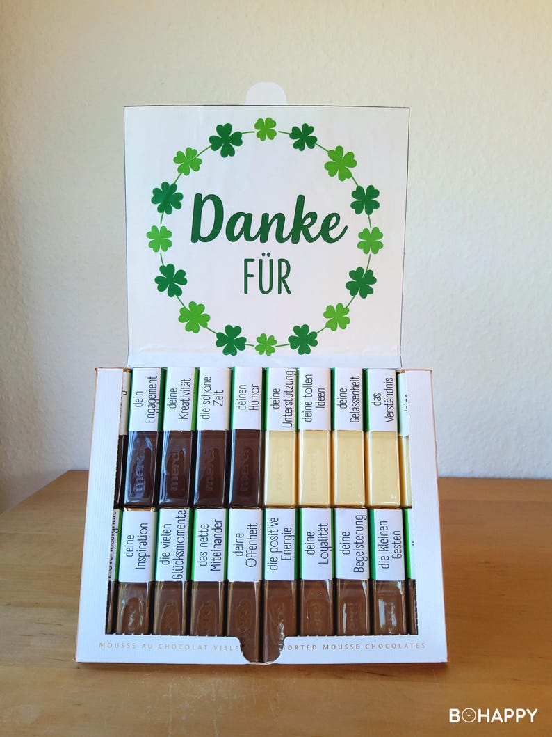 May include: A white box of assorted mousse chocolates with a green shamrock wreath and the German words "Danke F&uuml;r" on the lid. The chocolates have various German words on their wrappers.