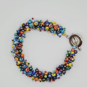 Unique intricately beaded bracelet in fun colors. It reminds me of a fuzzy fun caterpillar.  Handmade.  Clasp. Beaded bracelet. Vintage.