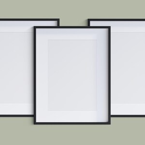 May include: Three black picture frames with white mounts and empty spaces for photos or artwork. The frames are arranged in a row, with the middle frame slightly higher than the other two.